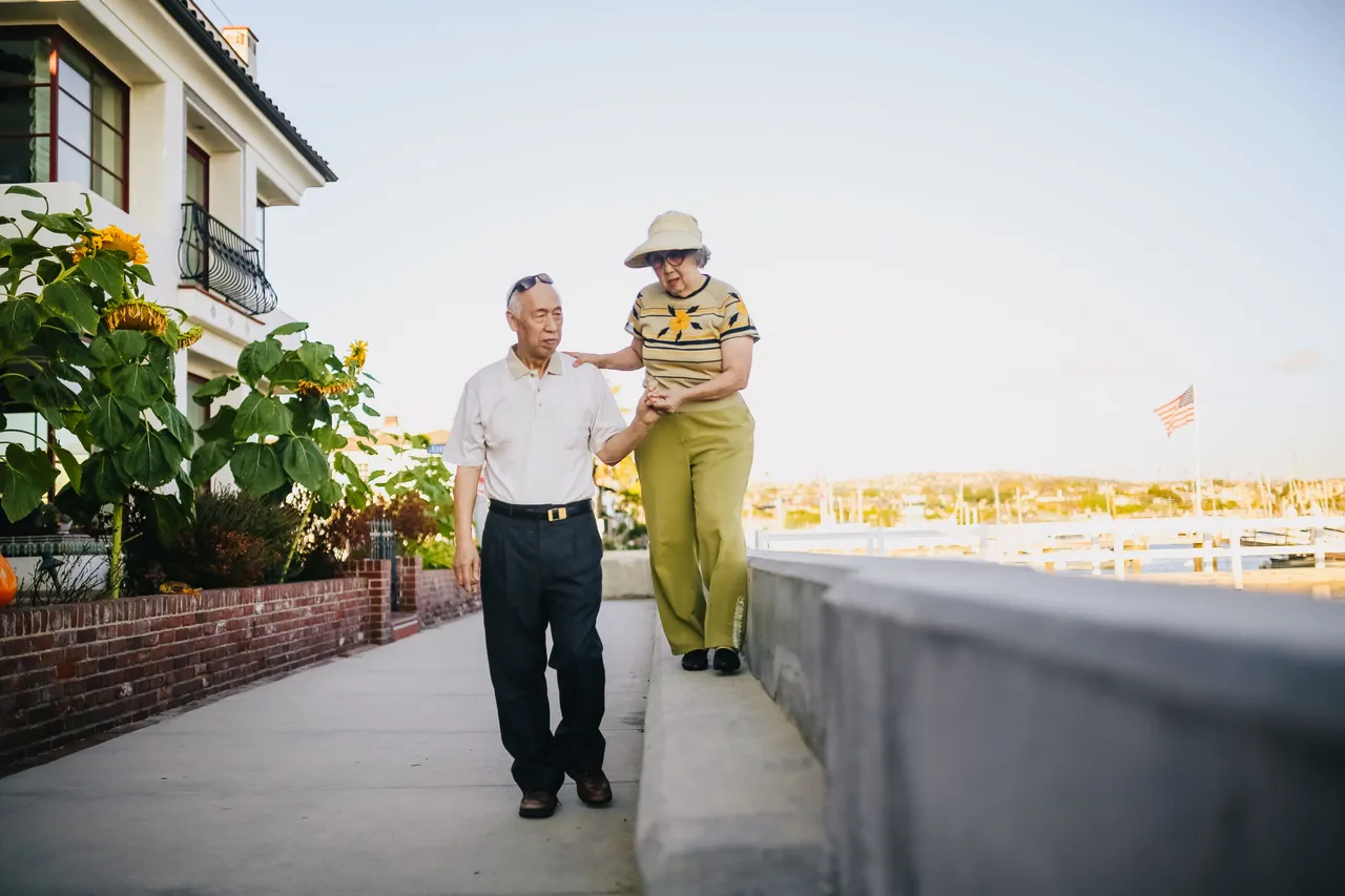 Older couple walking together outdoors.